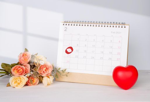 Calendar and flower and heart shape with memo 14 February Valentine day on desk, reminder for surprise of love, romance and sweet, celebration and decoration, top view, holiday concept.