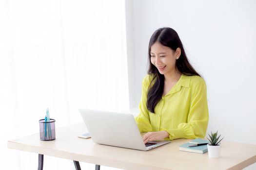 Young asian businesswoman working on laptop computer on desk at home office, freelance looking and typing on notebook on table, lifestyle of woman studying online, business and education concept.