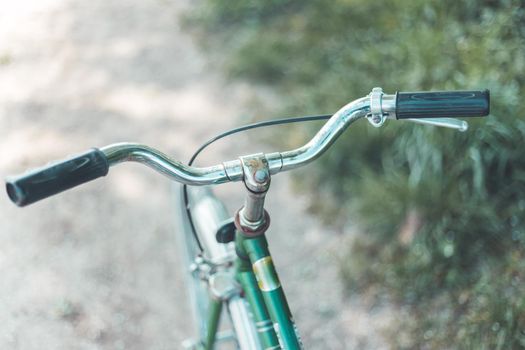 Closeup picture of a vintage bicycle handlebar and breaks outdoors, blurred background