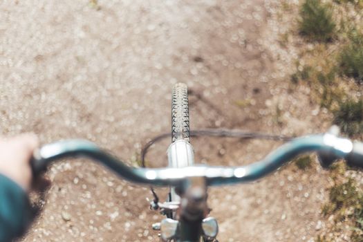 Close up picture of retro bike tire, blurry handlebar, summer day