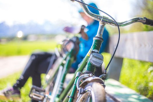 Front picture of a vintage retro bike, head reflectors. Girl sitting in blurry background.