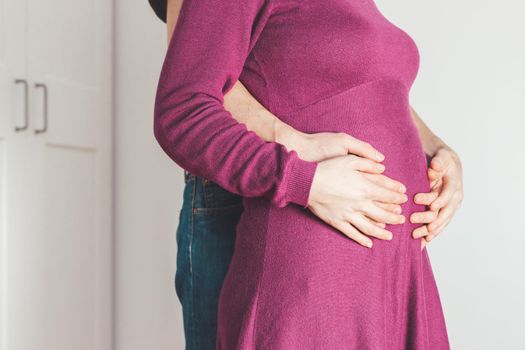 Close up of pregnant mother and father, hugging the tummy, Caucasian