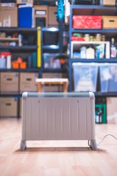 Electric heater, heating the basement. Blurry shelfs in the background