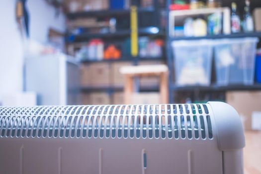 Electric heater, heating the basement. Blurry shelfs in the background