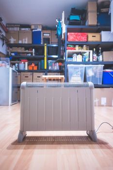 Electric heater, heating the basement. Blurry shelfs in the background