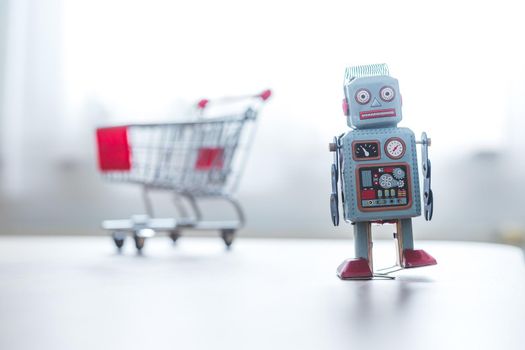 Online-Shopping concept: Toy robot and Miniature shopping cart