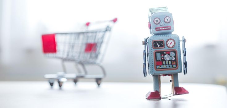 Online-Shopping concept: Toy robot and Miniature shopping cart