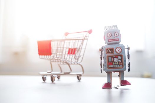 Online-Shopping concept: Toy robot and Miniature shopping cart