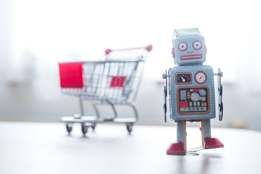 Online-Shopping concept: Toy robot and Miniature shopping cart