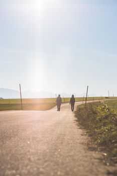 Two people are walking on an abandoned road