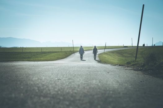 Two people are walking on an abandoned road