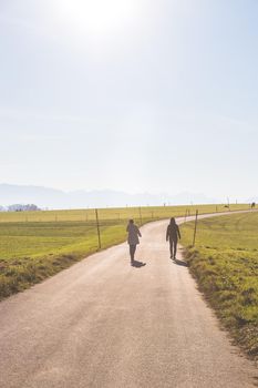 Two people are walking on an abandoned road