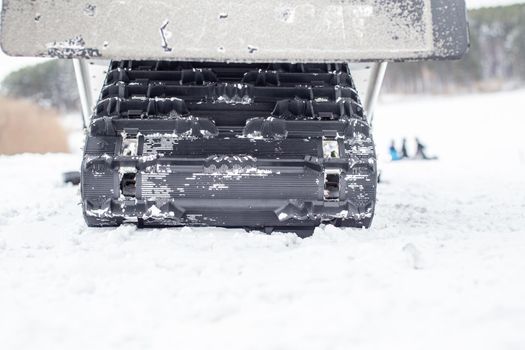 The back of the snowmobile in winter. Riding in the snow on a snowmobile. Rear suspension of a snowmobile