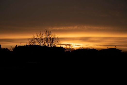 Silhouette of a Red sunset in a village during winter period