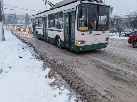 TULA, RUSSIA - NOVEMBER 21, 2020: Trolley bus arriving at station under snow on road at winter day.