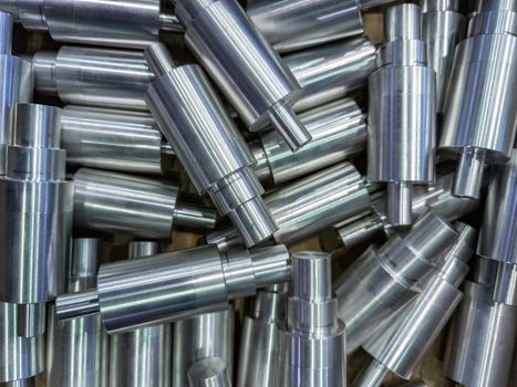 shiny cylindrical aluminium parts close-up full frame industrial production background
