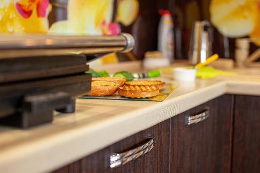 Making a sandwich in the kitchen at home. Fried bread rolls on the grill. the cooking process. The concept of healthy and unhealthy food.