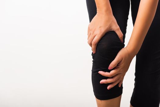 Closeup young woman aches to suffer from pain knee and she uses hand joint hold knee agony, studio shot isolated on white background Rheumatism healthcare and medical physiotherapy therapy concept