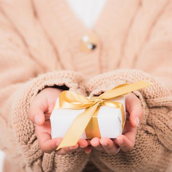 Valentine's Day. Woman beauty hands holding small gift package box present wrapped paper with ribbon isolated on white background, Birthday, New year, Christmas, holiday background concept