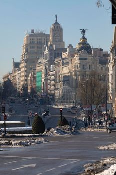 Madrid, Spain - January 17, 2021: General view of Alcalá and Gran Vía streets with the Metropolis building, still with some accumulated and dirty snow, without removing it for days, after Filomena.