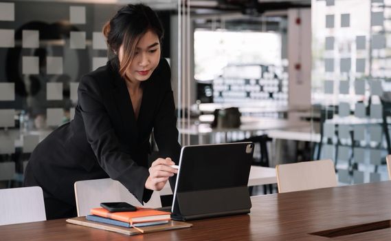 Young Asian Woman Working with Digital Tablet At Her Office. Business Financial Comcept