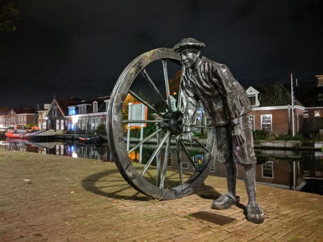 Statue along the canal at night in Sneek, Friesland, The Netherlands