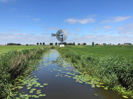 Canal and windmill around the village Boazum in Friesland The Netherlands