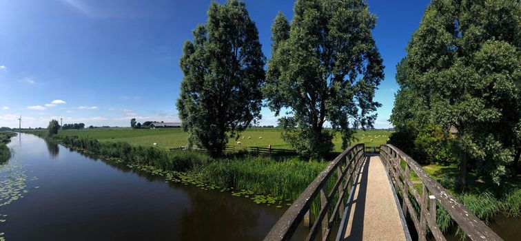 Panorama from a bridge over a canal in between Bartlehiem and Aldtsjerk in Friesland, The Netherlands