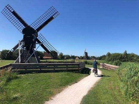 Man cycling towards IJlst, Friesland The Netherlands