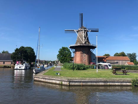 Windmill next to a canal in Burdaard, Friesland, The Netherlands