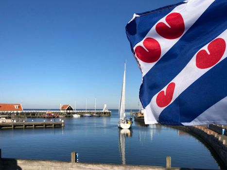 Frisian flag at the harbor in Hindeloopen during autumn in Friesland, The Netherlands
