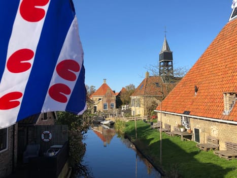 Frisian flag at a canal in Hindeloopen during autumn in Friesland, The Netherlands
