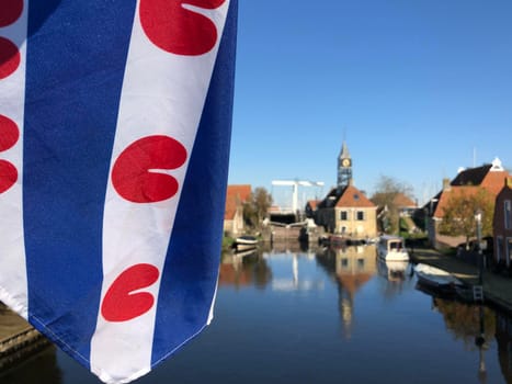 Frisian flag at a canal in Hindeloopen during autumn in Friesland, The Netherlands