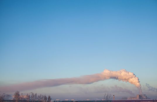 White thick smoke from the boiler room chimney. Smoke against the blue sky. Air pollution. Heating of the city. Industrial zone.