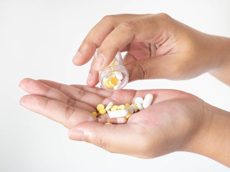 A woman pouring medicine onto her hand from a bottle On a white background