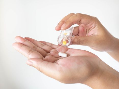 A woman pouring medicine onto her hand from a bottle On a white background