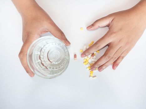 A woman with her hand on the drug The other hand was picking up a glass of water.