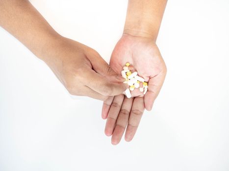 A woman picks up a pill from her hand White background.