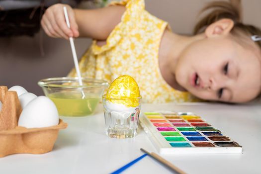 Cropped shot of adorable little girl painting egg for Easter.