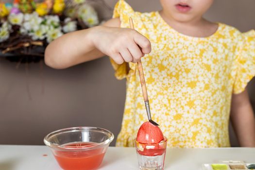 Cropped shot of adorable little girl painting egg for Easter.