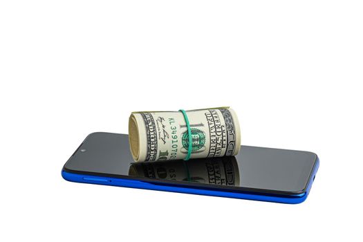 Money in a roll, tied with an elastic band, on the phone. The isolated object on a white background. U.S. dollars. Phone and dollars isolated on white.