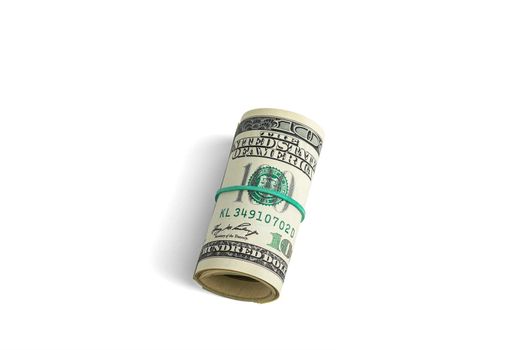 Money on a roll tied with an elastic band. The isolated object on a white background with a shadow. Close up photo of money. U.S. dollars. Banknotes. Paper money isolated on white background.