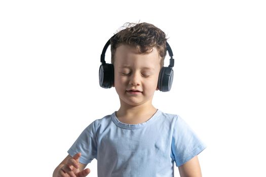 A beautiful European boy listens to music with headphones. Music lover since childhood. DJ. Isolated on white background.