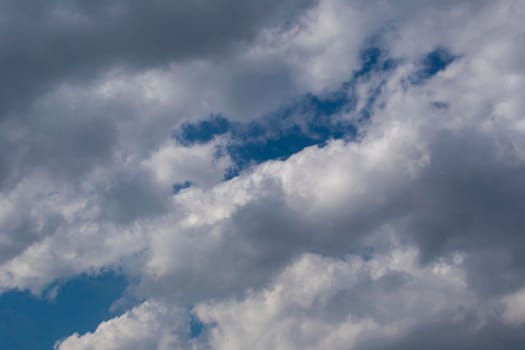 Slightly grey Cumulus clouds in a bright blue sky