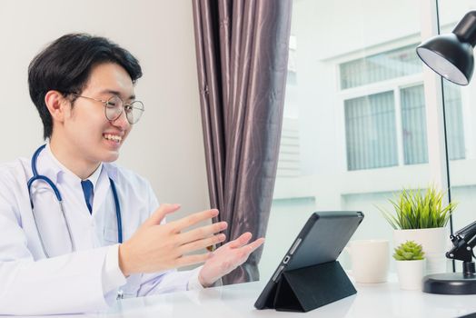 Happy Asian young doctor handsome man smile wear glasses use modern smart digital tablet computer explain patients symptoms of illness on desk at hospital office, Technology Healthcare And Medicine