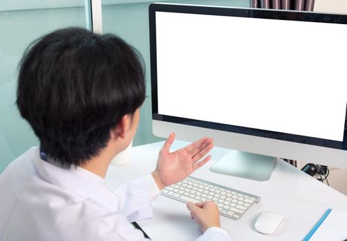 Asian young handsome doctor man wearing a doctor's dress and stethoscope video conference call or facetime raise hand to explain the symptoms he smiling at hospital office, Health medical care concept