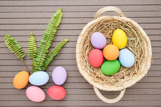 Close up Colorful easter eggs in the basket on wood background with space