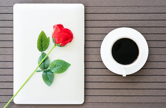 Top view coffee time valentine's day concept ,Desk table with laptop,notebook, coffee cup,red rose