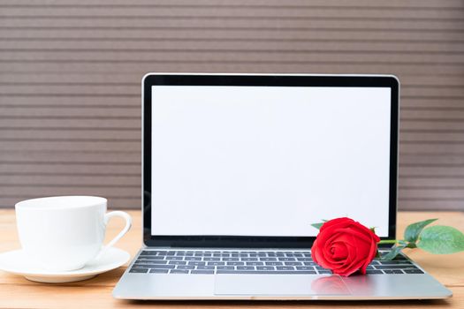 Red rose and coffee cup with laptop mockup on wood background, Valentine concept