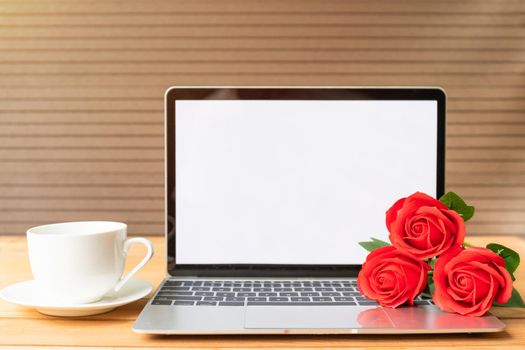 Red rose and coffee cup with laptop mockup on wood background, Valentine concept